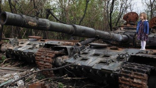 A child stands on a destroyed Russian tank, amid Russia's invasion of Ukraine, near Makariv, Kyiv ...