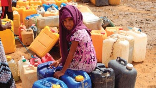 A yemeni girl waits as others fill their jerrycans with water at a makeshift camp for the internally ...