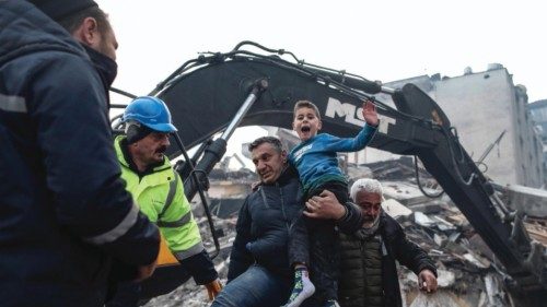 epa10453971 Eight-year-old Yigit Cakmak (C) reacts after being rescued from the site of a collapsed ...