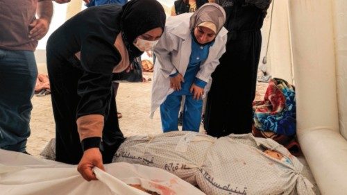 EDITORS NOTE: Graphic content / People inspect to identify one of the bodies of victims of the ...