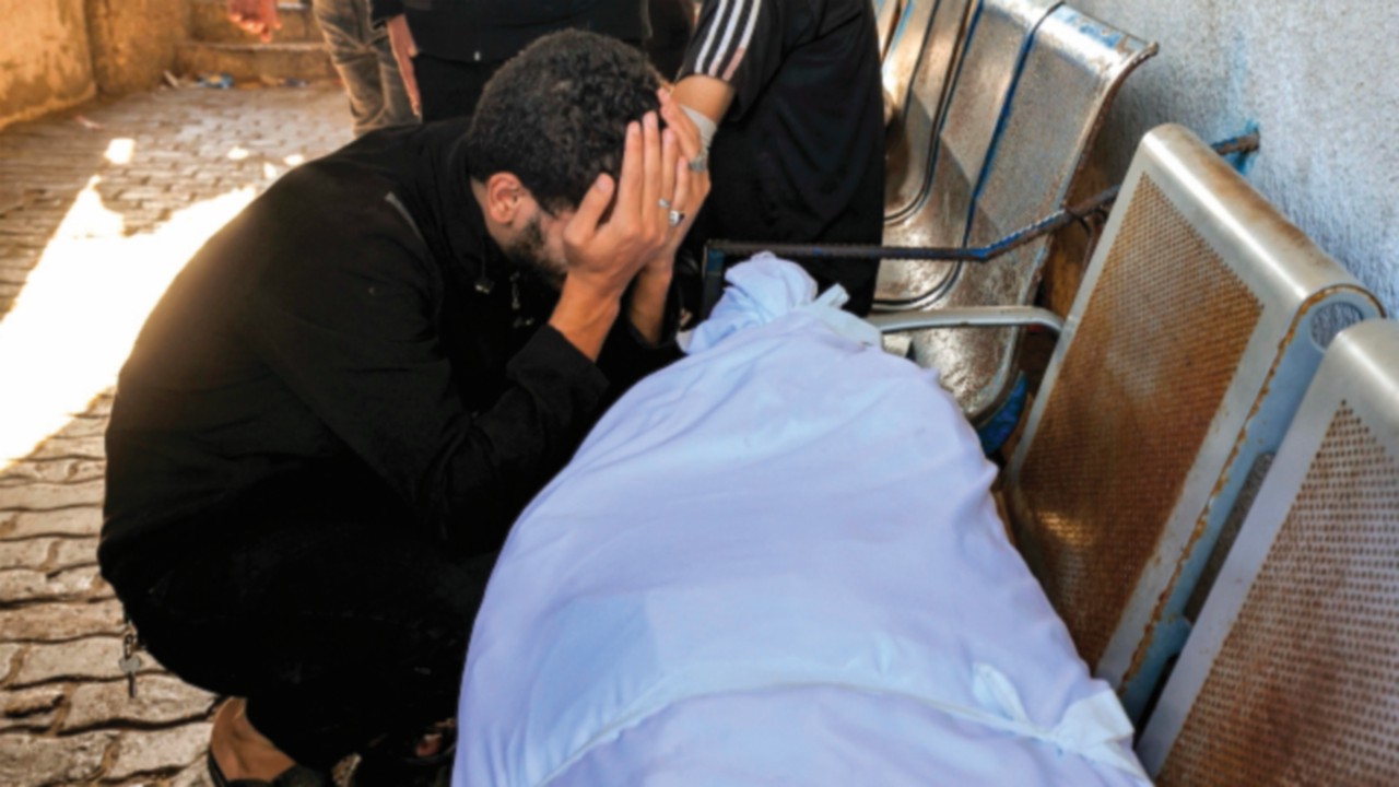 EDITORS NOTE: Graphic content / A man reacts by one of the wrapped bodies of victims who died in an ...