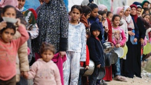 Palestinians stand in a line as they wait to receive food amid shortages of food supplies, amid the ... Palestinians stand in a line as they wait to receive food amid shortages of food supplies, amid the ...
