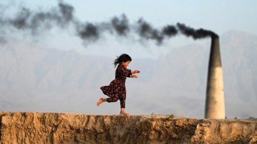 TOPSHOT - An Afghan girl runs across a brick kiln on the outskirts of Mazar-i-Sharif on June 22, ...